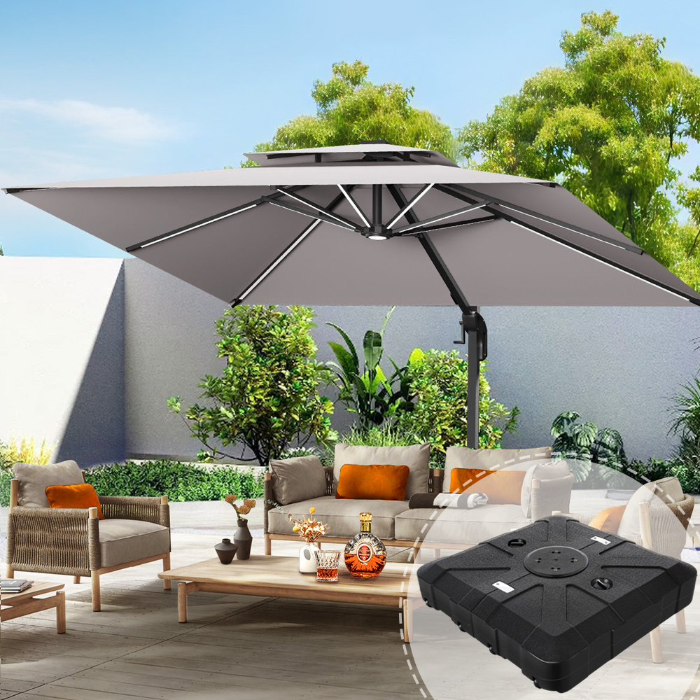 Patioslife 3×3m Charcoal Aegis Premium cantilever umbrella with heavy-duty base highlighted, over a modern outdoor lounge area with wicker furniture, wooden coffee table, green shrubs and a white privacy wall