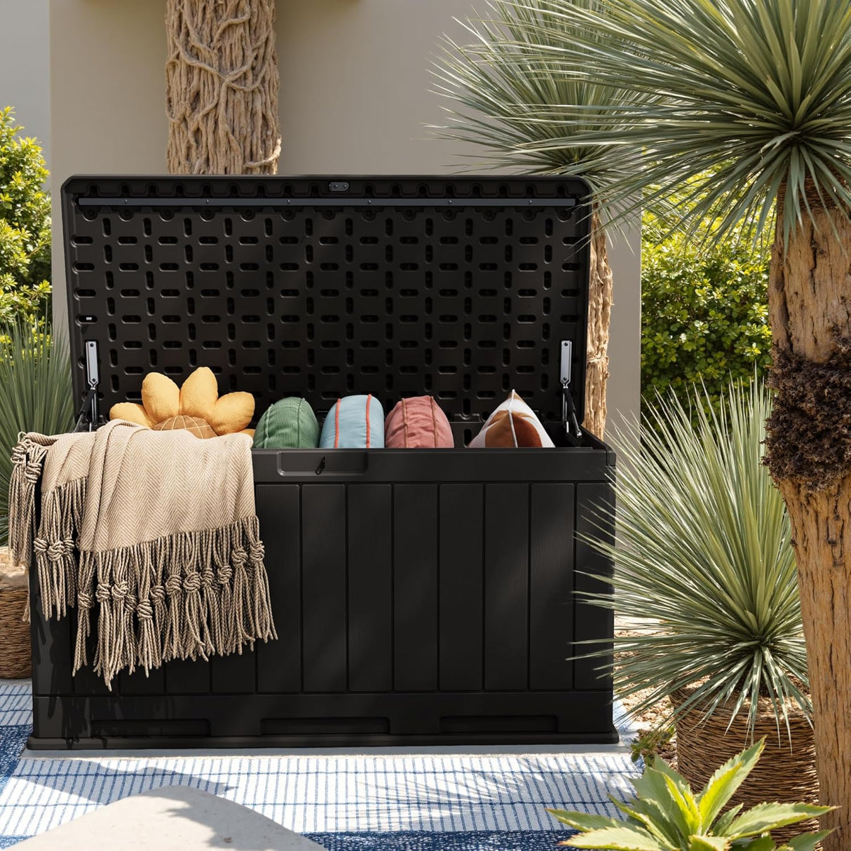 Outdoor deck box with hydraulic lid holding blankets and cushions, black resin patio storage box for outdoor use