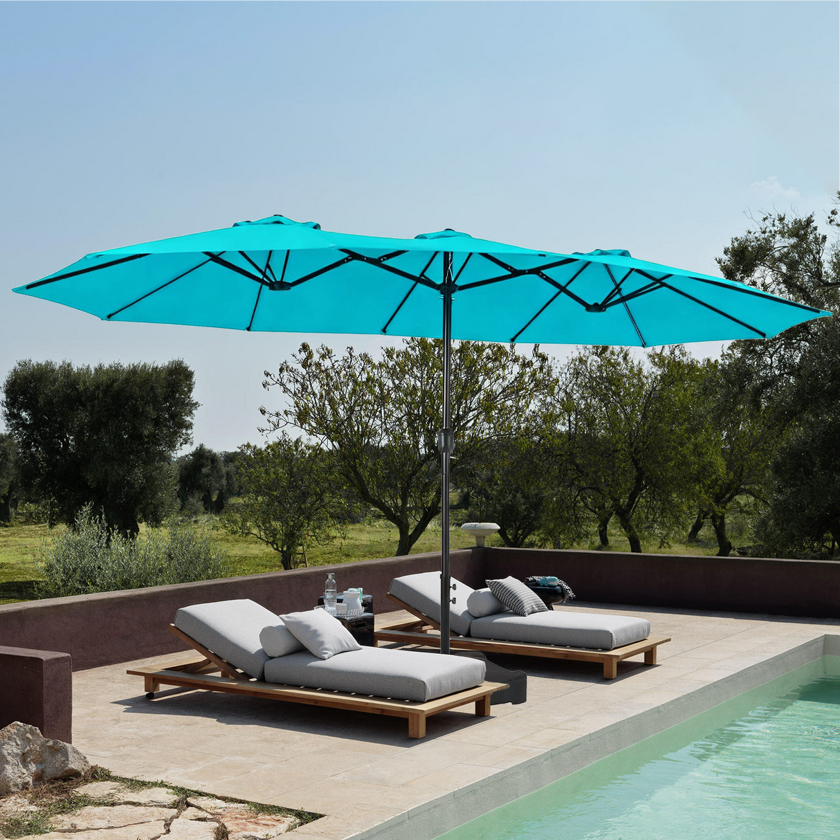 Patioslife Horizon Haven double-sided patio umbrella with base in sky blue, 4.6 x 2.7m, shading two poolside loungers on a terrace