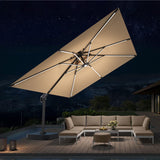 Patioslife 3×3m Tan Aegis Premium cantilever umbrella with full rib LED lighting over night poolside lounge area
