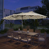 Patioslife Horizon Haven double-sided patio umbrella with base in cream, 4.6 x 2.7m, with LED lights over an outdoor dining set at night