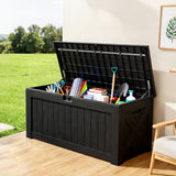 Large black outdoor deck box with open lid storing garden tools and household items, lockable resin storage box
