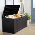 Outdoor deck box with open lid storing cushions and pool towels, large black resin weatherproof patio storage box