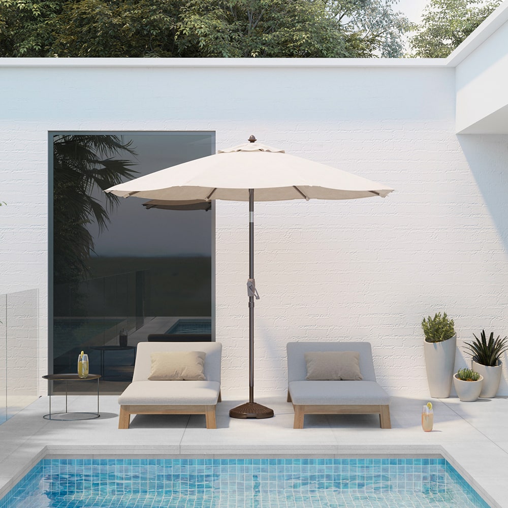 Patioslife Solara cream market umbrella beside a modern pool patio with white lounge chairs and minimalist outdoor setting