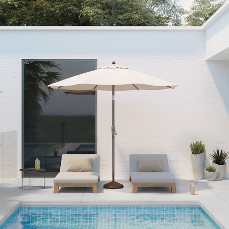 Patioslife Solara cream market umbrella beside a modern pool patio with white lounge chairs and minimalist outdoor setting
