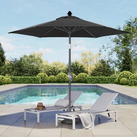 Patioslife Solara blackmarket umbrella beside a swimming pool with white sun loungers and garden greenery