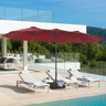 Patioslife Horizon Haven double-sided patio umbrella with base in red, 4.6 x 2.7m,with LED lights shading pool loungers beside a modern white villa